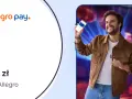 Radosny mężczyzna prezentuje telefon z aplikacją Allegro Pay, obiecując 50 zł do wykorzystania na zakupy.