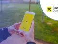 Dłonie trzymają smartfon z logo Raiffeisen Digital Bank.