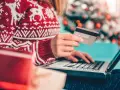 Karta kredytowa czy limit odnawialny? W świątecznym swetrze, z prezentami obok, kupuje online.