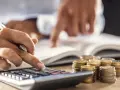 Rachunki, monety i kalkulator. Czy RRSO 120 procent to dużo? Analiza finansowa.
