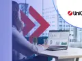 Kobieta analizuje dane na laptopie, obok logo UniCredit. Rozważasz UniCredit konto oszczędnościowe?