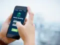 Dłoń trzyma smartfon z aplikacją Aion Bank. Logowanie do bankowości mobilnej, by uniknąć problemów z komornikiem.