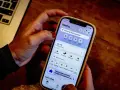 Dłoń trzyma smartfon z aplikacją Klarna. Czy Klarna jest bezpieczna? Aplikacja oferuje zakupy, płatności i zarządzanie zamówieniami.