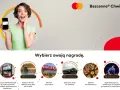 Kobieta z uśmiechem prezentuje telefon z kartą Mastercard, zachęcając do wyboru nagrody w ramach "Bezcenne Chwile".