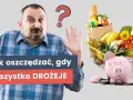 Zaskoczony mężczyzna z pytajnikiem nad głową i rozbita skarbonka obok koszyka z zakupami. Jak oszczędzać na zakupach, gdy wszystko drożeje?