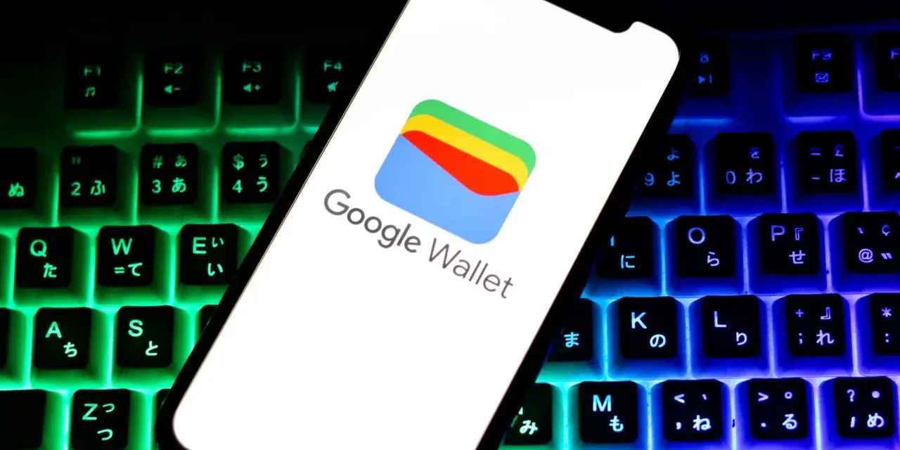 Smartfon z logo Google Wallet na tle podświetlanej klawiatury. Czy portfel Google jest bezpieczny? Odpowiedź znajdziesz w cyfrowym świecie.