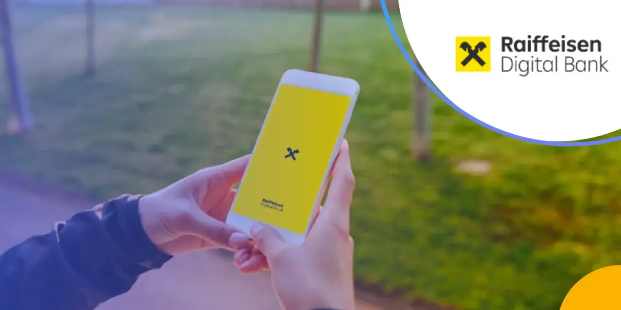 Dłonie trzymają smartfon z logo Raiffeisen Digital Bank.
