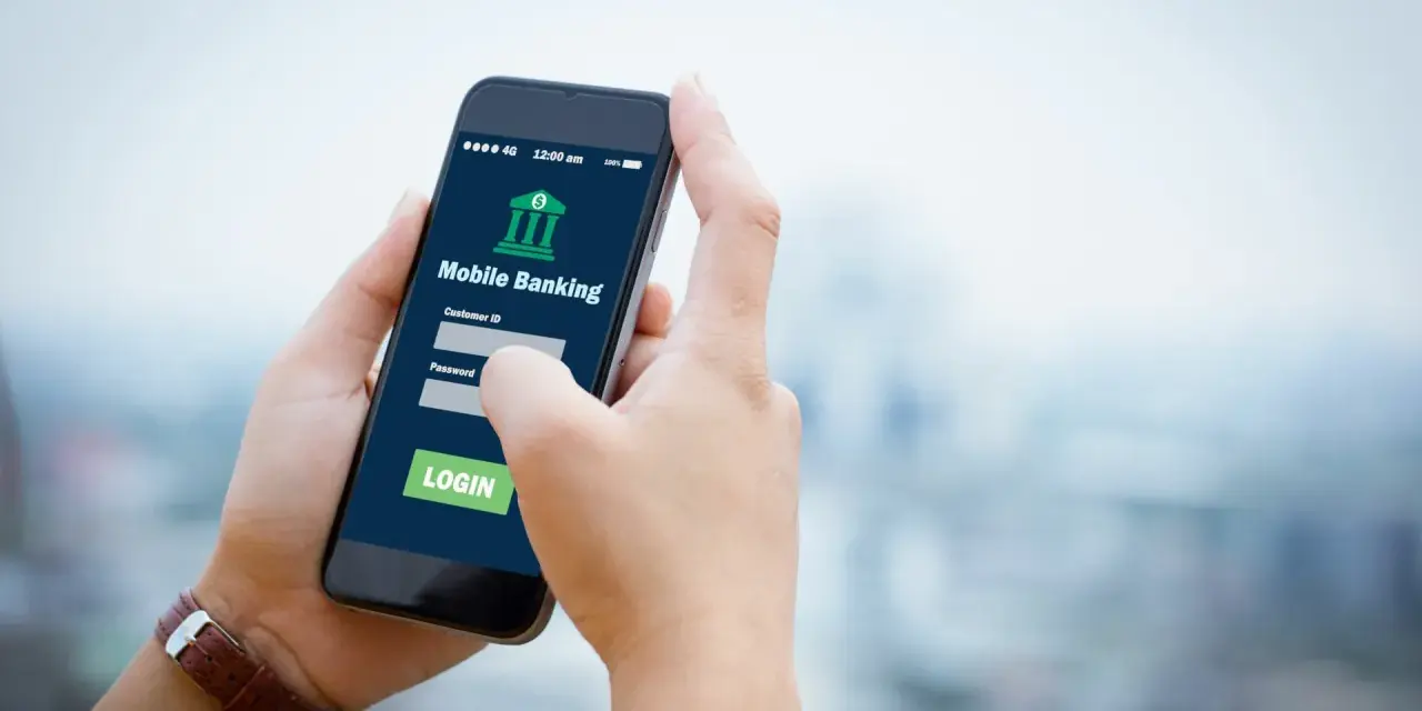 Dłoń trzyma smartfon z aplikacją Aion Bank. Logowanie do bankowości mobilnej, by uniknąć problemów z komornikiem.