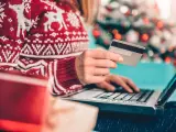 Karta kredytowa czy limit odnawialny? W świątecznym swetrze, z prezentami obok, kupuje online.