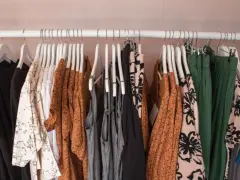 Ubrania na wieszakach: czarne, białe z czarnym wzorem, pomarańczowe, szare, zielone. To co to jest halfprice? To okazja na stylowe zakupy!