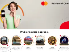 Kobieta z uśmiechem prezentuje telefon z kartą Mastercard, zachęcając do wyboru nagrody w ramach "Bezcenne Chwile".