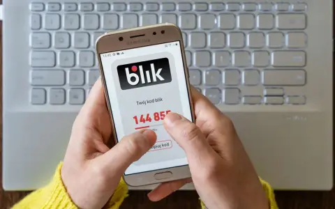 Ręce trzymają telefon z aplikacją Blik, na ekranie widoczny kod. Zastanawiasz się, jak cofnąć Blik? Ten obraz pokazuje, jak szybko uzyskać kod.