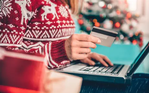 Karta kredytowa czy limit odnawialny? W świątecznym swetrze, z prezentami obok, kupuje online.