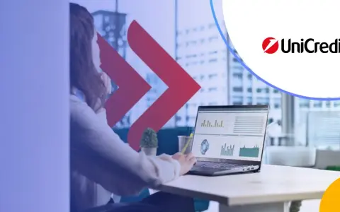 Kobieta analizuje dane na laptopie, obok logo UniCredit. Rozważasz UniCredit konto oszczędnościowe?