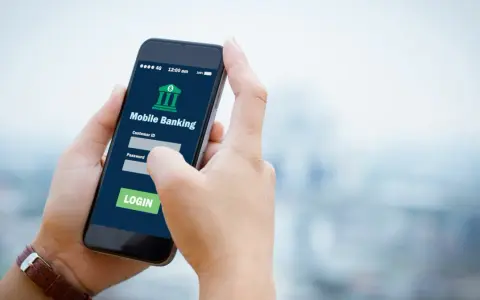 Dłoń trzyma smartfon z aplikacją Aion Bank. Logowanie do bankowości mobilnej, by uniknąć problemów z komornikiem.