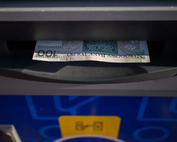 Banknot 100 zł włożony do wpłatomatu. Tak działa wpłatomat: wkładasz pieniądze, a urządzenie je przyjmuje.