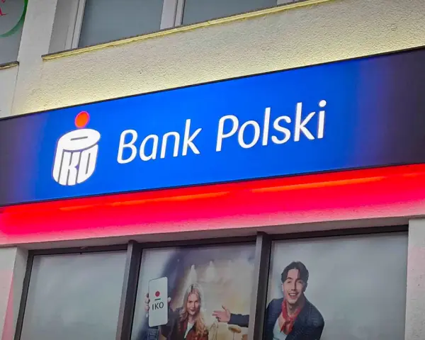 Reklama PKO Bank Polski z hasłem "kiedy nowe lokaty w pko bp". Jasny neon z logo banku i czerwone podświetlenie.