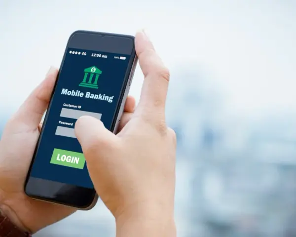 Dłoń trzyma smartfon z aplikacją Aion Bank. Logowanie do bankowości mobilnej, by uniknąć problemów z komornikiem.