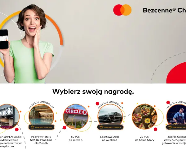 Kobieta z uśmiechem prezentuje telefon z kartą Mastercard, zachęcając do wyboru nagrody w ramach "Bezcenne Chwile".