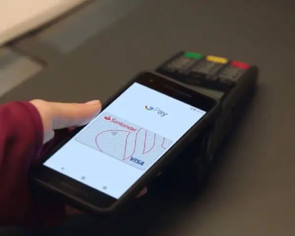 Zbliżenie na telefon z ekranem Google Pay, pokazujące jak działa płatność zbliżeniowa kartą Santander Visa.