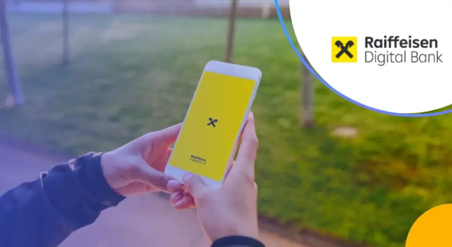 Dłonie trzymają smartfon z logo Raiffeisen Digital Bank.