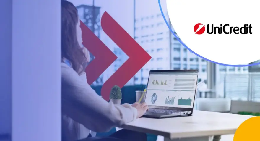 Kobieta analizuje dane na laptopie, obok logo UniCredit. Rozważasz UniCredit konto oszczędnościowe?