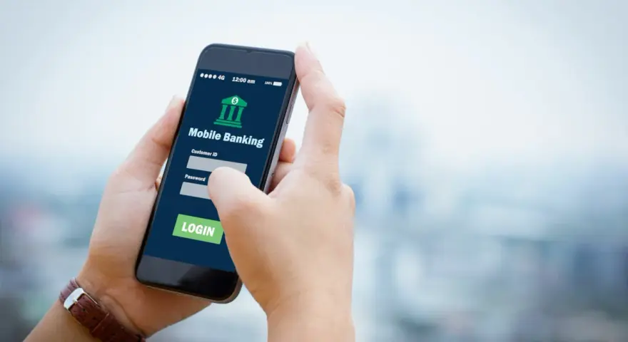 Dłoń trzyma smartfon z aplikacją Aion Bank. Logowanie do bankowości mobilnej, by uniknąć problemów z komornikiem.