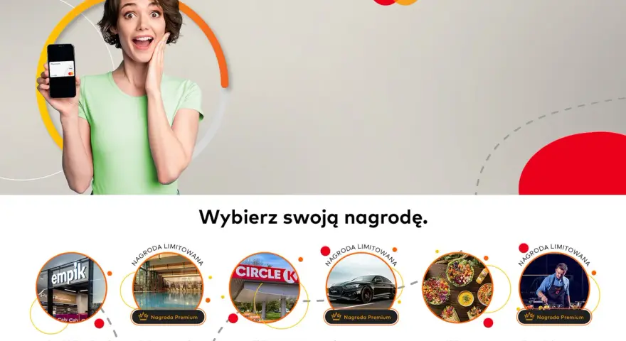 Kobieta z uśmiechem prezentuje telefon z kartą Mastercard, zachęcając do wyboru nagrody w ramach "Bezcenne Chwile".