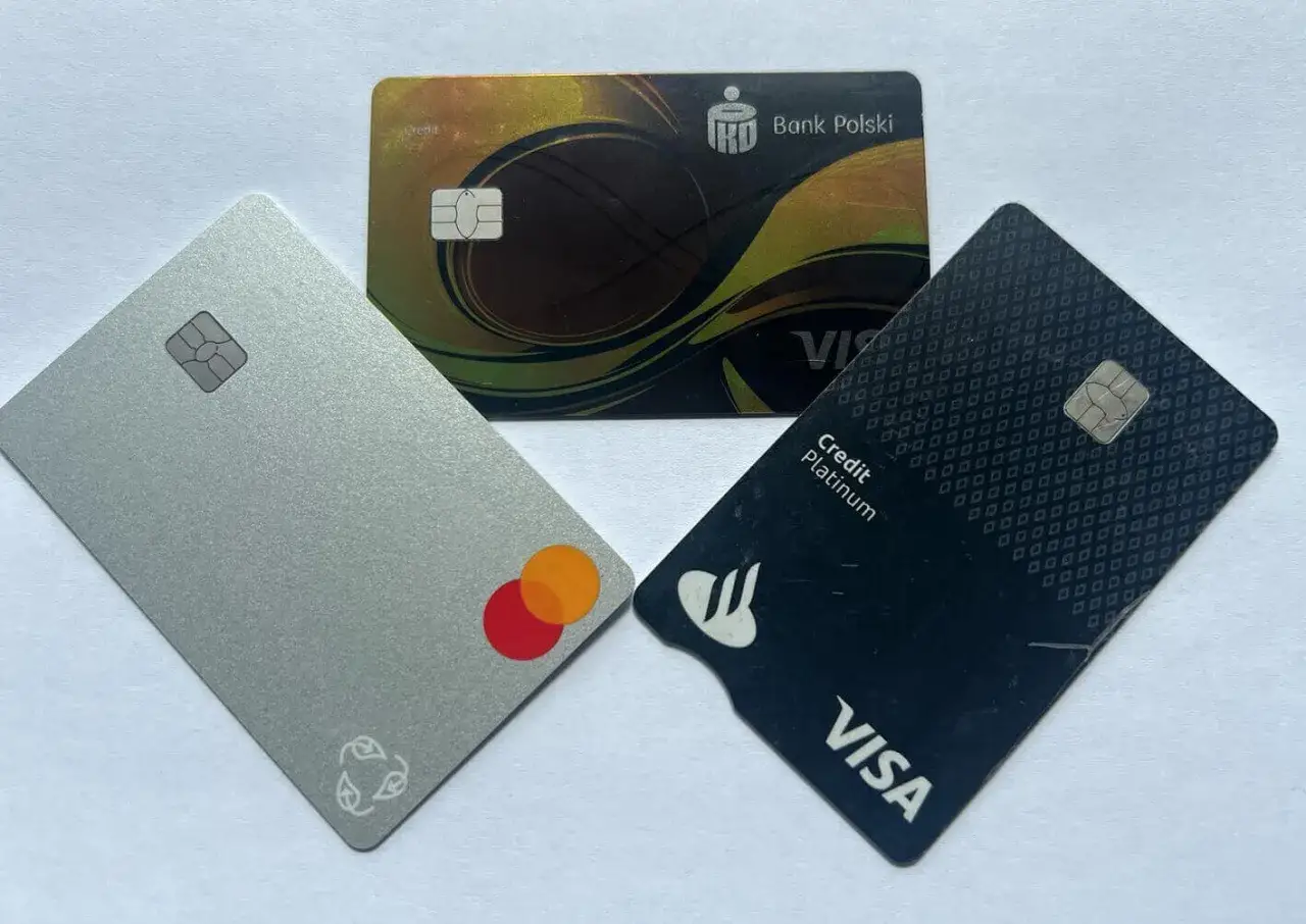 Trzy karty płatnicze: srebrna z logo Mastercard, czarna z logo Visa Credit Platinum i złota z logo Banku Polskiego. Wyb&oacute;r między Mastercard czy Visa.